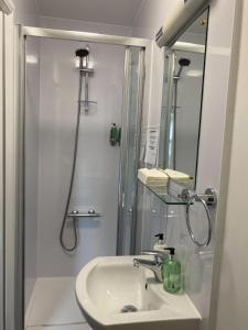 W łazience znajduje się umywalka i prysznic. w obiekcie Richmond House Hotel w mieście Fort Augustus