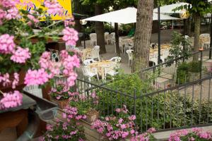 a garden with pink flowers and tables and chairs at Hotel Ristorante Tre Stelle in Montepulciano