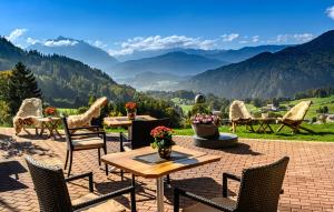 d'une terrasse avec des chaises et une table offrant une vue sur les montagnes. dans l'établissement Alpenhotel Denninglehen, à Berchtesgaden