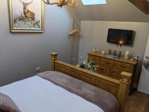 a bedroom with a bed and a tv on a dresser at The Stables - Bankshill in Lockerbie