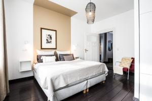 ein Schlafzimmer mit einem großen weißen Bett und einem Stuhl in der Unterkunft Villa B - Neuer Geist in alten Mauern: luxuriös Wohnen in der Residenzstadt Gotha in Gotha