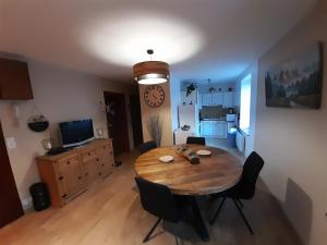 een eetkamer met een tafel en een klok aan de muur bij Chez la malou in La Bresse