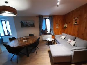 een woonkamer met een bank en een tafel bij Chez la malou in La Bresse