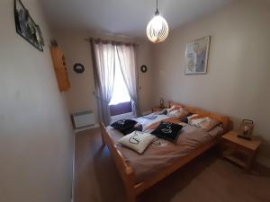 een slaapkamer met een bed met kussens erop bij Chez la malou in La Bresse