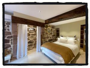 a bedroom with a large bed with a stone wall at Chambres d'Hôtes Maison E.Bernat in Saint-Jean-Pied-de-Port