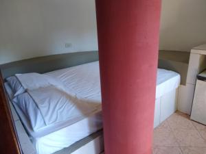 a small bed in a room with a red pole at Hotel Serra De Penedo in Penedo