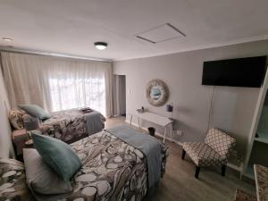 ein Hotelzimmer mit 2 Betten und einem TV in der Unterkunft THE SPARE BEDROOM Unit 2 in Harrismith