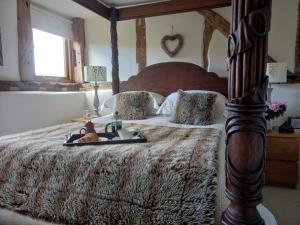 Un dormitorio con una cama con una bandeja de comida. en The Barn at Titley, en Kington