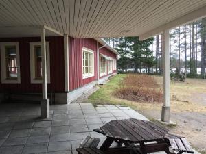 a picnic table in front of a red house at NORDIC LAKES OY/AB in Taivalkoski