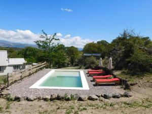 a swimming pool with lounge chairs next to a house at 7 esencias in Villa Yacanto