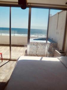 een slaapkamer met uitzicht op het strand vanuit een raam bij Hotel "CASA MANGATA" in Puerto Arista