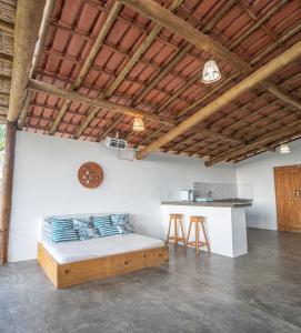 1 dormitorio con 1 cama en una habitación con barra en Welove Beach House-Pés na areia Quintal dos Sonhos, en Serra Grande
