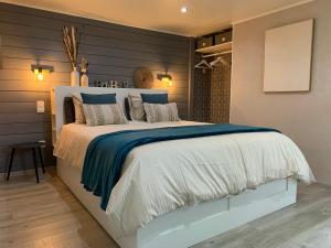 1 dormitorio con 1 cama grande con sábanas azules y blancas en Country house Au Ballet des Hirondelles, en Herve