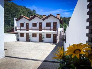 ein großes weißes Haus mit vielen Fenstern in der Unterkunft Recanto Bella Fonte in Monte Verde