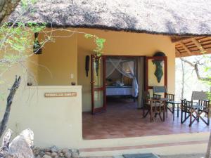 a house with a thatch roof and a patio at Masodini Game Lodge in Hoedspruit