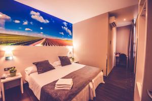 a hotel room with a bed and a painting on the wall at Hostal Prado in Madrid