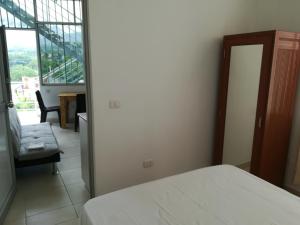 1 dormitorio con 1 cama, 1 silla y 1 ventana en La Casa Del Italiano, en Tarapoto