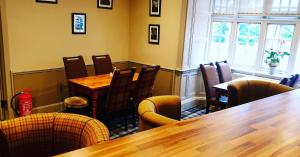 un restaurante con mesas y sillas de madera y una ventana en Garth Hotel, en Grantown-on-Spey