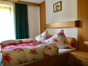 Un dormitorio con una cama con flores. en Ferienwohnungen Luxner, en Fügen
