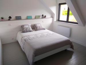 a white bedroom with a bed and a window at Maison Cosy entre CAP FREHEL et SAINT MALO 1km PLAGE 5min GR34 Wifi Jardin Vélos "CASA OHANA" in Saint-Cast-le-Guildo