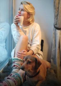 a woman is sitting on the floor with a dog at Family house in Druskininkai