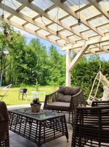 un patio con sillas, una mesa y un columpio en Family house, en Druskininkai