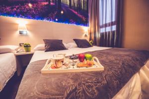 a tray of food on a bed in a hotel room at Hostal Prado in Madrid