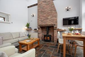 ein Wohnzimmer mit Couch und Kamin in der Unterkunft Swift Cottage in Broadhempston