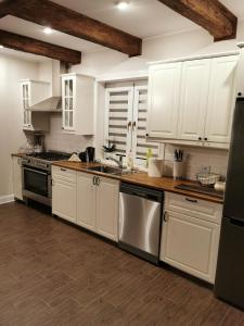 a kitchen with white cabinets and stainless steel appliances at Bogdanówka in Skalnik