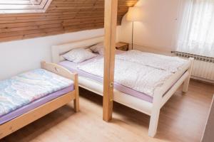 two bunk beds in a room with wooden walls at Planinska kuća za odmor Vuković in Podgrab