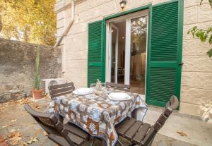 a table and chairs on a patio with green shutters at Podere Sant'Antonio da Zio Gino in Bolsena