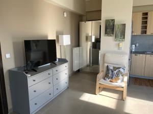 un soggiorno con cassettiera, TV e sedia di Breathtaking view guesthouse a Psalidi