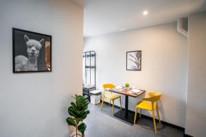 a dining room with a table and yellow chairs at Chulia Heritage Studio in George Town