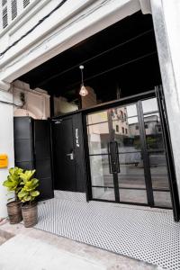 un garaje con una puerta negra y algunas plantas en Chulia Heritage Studio, en George Town