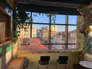 a room with chairs, tables, and windows at Hostel Market in Porto