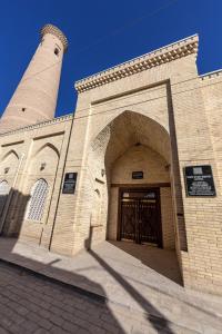 a building with a gate and a clock tower at New Star Boutique hotel - madrasah Muhammad Mahram 1903 in Khiva