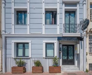 a white building with two potted plants in front of it at Okda Hotel in Istanbul