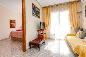 a bedroom with a couch and a tv and a window at Apartament Caballero de Rodas in Torrevieja