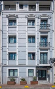 a white building with windows and plants in front of it at Okda Hotel in Istanbul