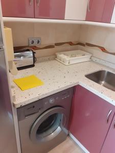 una pequeña cocina con lavadora y fregadero en Albaida II Bajo G Apartamento Nerja, en Nerja