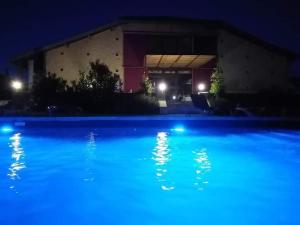 a blue swimming pool at night with a building at exceptionnel loft style industriel tout équipé 15 personnes avec jacuzzi in Villebramar