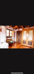 a bedroom with a bed and wooden floors and windows at La Colegiata De Ronda in Ronda