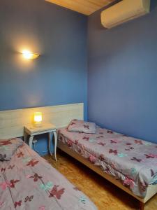 um quarto com 2 camas e uma pequena mesa com uma cama em Gîte de la Grenouille - 5-7 places - vallée d'Aure em Lortet
