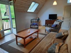 uma sala de estar com um sofá e uma mesa em Gîte de la Grenouille - 5-7 places - vallée d'Aure em Lortet