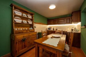 una cucina con pareti verdi e tavolo in legno di Maison Chacard cir0039 a Pila