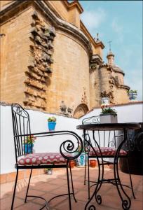 una mesa, una silla, una mesa y un edificio en La Colegiata De Ronda, en Ronda