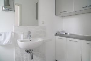 un bagno bianco con lavandino e armadi bianchi di Modernes Stadthaus 100qm Parkplatz Bad&Dusche Küche ad Hannover Altre 19 foto