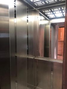 un ascensor de acero inoxidable en una habitación con espejo en Okda Hotel, en Estambul