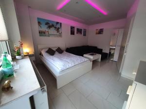 ein Schlafzimmer mit einem Bett und rosa Lichtern an der Decke in der Unterkunft Miami Apartment in Paderborn