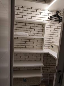 um closet com paredes de tijolos brancos e prateleiras brancas em JK Luxury Stay em São Paulo